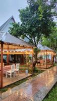 a pavilion with chairs and a table and a tree at Carambola Lodge in Phong Nha