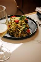 een bord pasta met tomaten en een glas wijn bij The Max Hotel Sandton in Johannesburg
