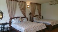 a bedroom with two beds and a table and curtains at Gengmengyuan B&amp;B in Xikou