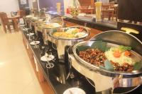 Una línea de buffet con muchos tipos diferentes de comida. en Prima SR Hotel & Convention Yogyakarta, en Yogyakarta