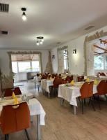 4 Hordó - Panzió és Étterem في كوماروم: غرفة طعام بها طاولات وكراسي بيضاء