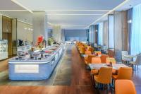 a restaurant with a long line of tables and chairs at Novotel Jinan Airport in Jinan