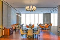 a dining room with tables and chairs and windows at Novotel Jinan Airport in Jinan