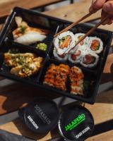 Thon Partner Hotel Parken في كريستيانساند: شخص يأكل السوشي باستخدام عيدان الطعام في صينية طعام