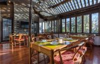 a dining room with tables and chairs and windows at Yyj Island Garden Resorts Lijiang in Lijiang