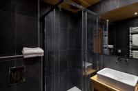 a black bathroom with a sink and a shower at Studio Beauregard in Le Grand-Bornand