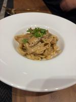 une assiette blanche de pâtes avec du poulet par-dessus dans l'établissement sorahama, à Tottori