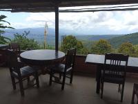 Ein Tisch und Stühle auf einem Balkon mit Aussicht in der Unterkunft Sunset villa munduk in Munduk