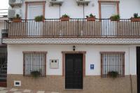 a building with a balcony with plants on it at Hostal Caminito del Rey in Alora