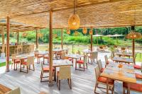 een restaurant met houten tafels en stoelen en een terras bij The Riverfront Reserve in Pai