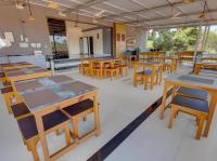 um restaurante com mesas e cadeiras de madeira em uma sala em Hotel 7Seas by Solara Hospitality em Vagator