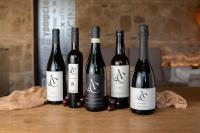 four bottles of wine sitting on a wooden table at Hotel Boutique Patio del Posadero in Córdoba