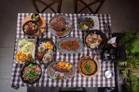 una mesa con platos de comida en un mantel a cuadros en Solis Luxury Motel, en Skopje