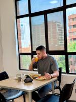 a man sitting at a table drinking a drink at Hotel Plaza Mayor 44 in Medellín
