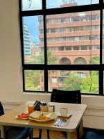 a table with a plate of food on it in front of a window at Hotel Plaza Mayor 44 in Medellín