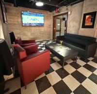 a room with a couch and a table and a tv at The Maverick, powered by Placemakr - River Walk in San Antonio