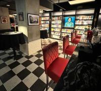 a library with red chairs and a table and books at The Maverick, powered by Placemakr - River Walk in San Antonio