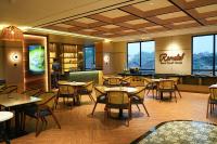 ein Restaurant mit Tischen, Stühlen und Fenstern in der Unterkunft Cordela Suites Cianjur in Cianjur