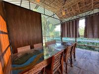 Un comedor con una mesa de cristal y sillas. en Kaziranga Tea Nest Homestay, en Kāziranga