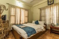 een slaapkamer met een bed met een blauwe deken erop bij Hotel Orchid - Family-Run, Family-Care in Sauraha