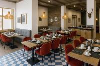 un restaurant avec des tables en bois et des chaises rouges dans l'établissement SOWELL FAMILY Vars, à Vars