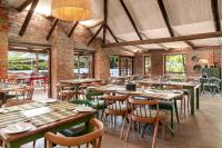 een restaurant met houten tafels en stoelen en ramen bij Elgin River Lodge in Elgin