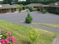 a bush sitting in the middle of a parking lot at Relais des 3 Pommes in Bayeux