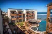 eine Luftaufnahme eines Resorts mit Swimmingpool und Meer in der Unterkunft Le Battant Des Lames in Saint-Pierre