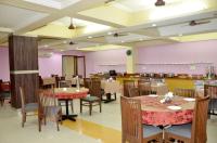 comedor con mesas, sillas y paredes rosas en Hotel Heeralal, en Bikaner