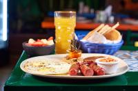 Un plato de comida de desayuno sobre una mesa verde. en Encanto Lodge, en Lagos
