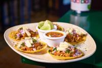 Un plato de comida con tacos y salsa y gajos de lima. en Encanto Lodge, en Lagos