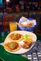 Un plato con dos pizzas y un vaso de zumo de naranja. en Encanto Lodge, en Lagos