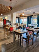 Un restaurante con mesas y sillas de madera y ventanas. en NESTOR HOTEL GAP et Restaurant, en Gap