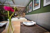 um restaurante com uma mesa e um vaso com uma flor em Hotel Azenberg em Estugarda