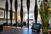 um comprimido sentado numa mesa com um vaso de flores em Hotel Azenberg em Estugarda