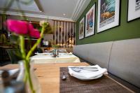 uma sala de jantar com duas mesas com guardanapos brancos em Hotel Azenberg em Estugarda