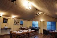 Una gran sala con mesas y sillas. en Shikaar Valley, en Khilchīpur