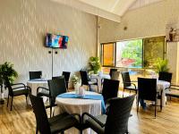 een restaurant met tafels en stoelen en een tv aan de muur bij Shanvilla Resort Ltd in Murangʼa