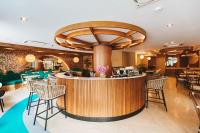 un restaurante con barra con sillas y mesas en The Proud Rawai Resort, en Rawai Beach