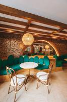 un comedor con un sofá verde y sillas en The Proud Rawai Resort, en Rawai Beach