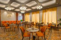 um restaurante com mesas e cadeiras em uma sala em Hotel Marrion em Amritsar