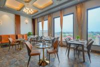 um restaurante com mesas e cadeiras e grandes janelas em Hotel Marrion em Amritsar