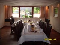 a dining room with a long table with white table cloth at Landhotel Pingel in Sundern