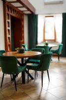 ヤレムチャにあるGots - готельно-ресторанний комплексのダイニングルーム(テーブル、緑の椅子付)