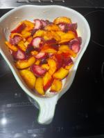 Un recipiente blanco lleno de fruta sobre una mesa. en Le Manoir des Remparts de Besse, en Besse-et-Saint-Anastaise