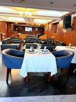 un restaurante con una mesa y sillas y una mesa y sillas en Appart'hôtel Micheline Suites & SPA, Bastos, en Yaoundé
