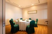a meeting room with a table and green chairs at Oriental Elegant Hotel in Libeiling