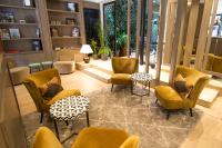 a lobby with yellow chairs and tables and windows at Waldorf Montparnasse in Paris