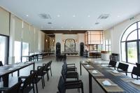 een restaurant met lange tafels, stoelen en ramen bij Polaris Resort & Spa in Xóm Tram