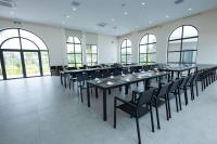 een grote kamer met tafels, stoelen en ramen bij Polaris Resort & Spa in Xóm Tram